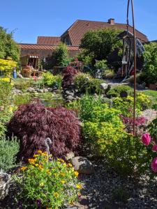 un giardino con fiori colorati e un laghetto di Eulennest a Tarp