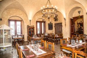 een restaurant met tafels en stoelen en een kroonluchter bij Chateau Zbiroh in Zbiroh
