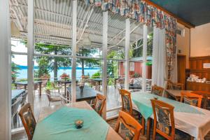 una sala da pranzo con tavoli e sedie e vista sull'oceano di Maestral Residence a Portoroz