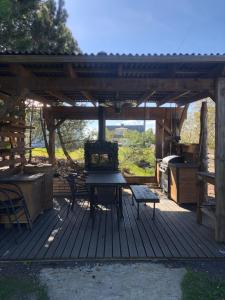 une terrasse en bois avec un grill et une table de pique-nique dans l'établissement Kalvi tee Puhkemaja, à Viru-Nigula