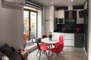 a kitchen and living room with a table and chairs at Apartamento de diseño céntrico a 5 min de playa (1º) in Alicante