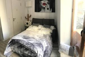 a bedroom with a bed with a black and white comforter at Apartamento de diseño céntrico a 5 min de playa (1º) in Alicante