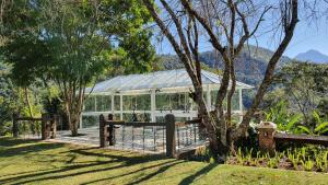 uma estufa num jardim com uma cerca de madeira em Quinta da Paz Resort em Itaipava