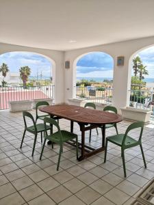 een tafel en stoelen in een kamer met 2 ramen bij Le sorgenti camere e appartamenti in Torre Vado