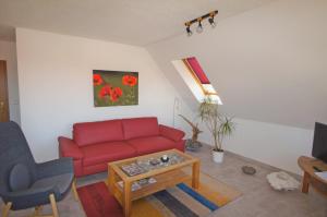 a living room with a red couch and a table at Ferienwohnungen Arkonablick in Lohme