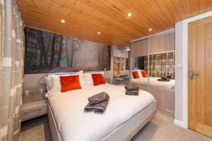 a bedroom with a large white bed with orange pillows at Mistletoe One Luxury Lodge with Hot Tub Windermere in Windermere +43 photos