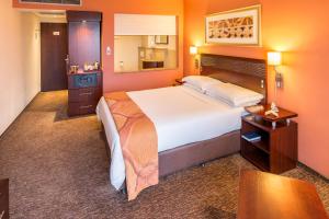 a hotel room with a large bed and a table at City Lodge Hotel Hatfield, Pretoria in Pretoria