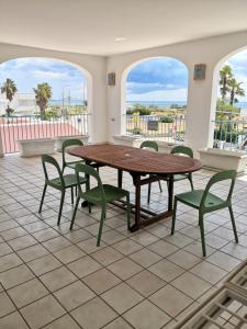 stół i krzesła w pokoju z dwoma oknami w obiekcie Le sorgenti camere e appartamenti w mieście Torre Vado