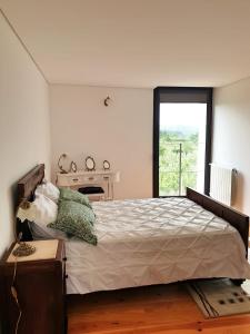 a bedroom with a large bed and a window at Casa das Hortênsias in Alijó