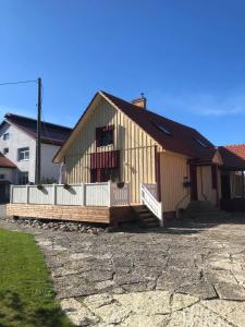 - un grand bâtiment en bois avec une terrasse couverte dans l'établissement Kalvi tee Puhkemaja, à Viru-Nigula