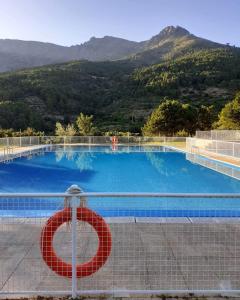 a swimming pool with a no sign on a fence at Hotel Rural Los Molinillos in El Arenal