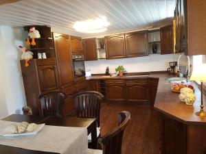 a kitchen with wooden cabinets and a table and a dining room at Pilgrims "Elfriede"- freundliche Unterkunft in Remblinghausen