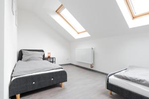 two beds in a white room with skylights at Moderne City Appartments im Stadtzentrum in Chemnitz