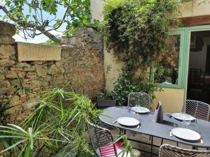 a blue table and chairs in a garden at Les chemins de la Cité Chambre ou appartement in Carcassonne