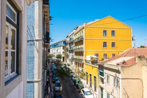 Blick auf eine Stadtstraße mit gelben Gebäuden in der Unterkunft Bhappy@home Lisboa in Lissabon