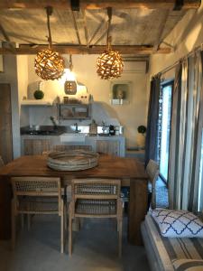 une cuisine avec une table en bois, des chaises et des lumières dans l'établissement Istron Breeze Isla, à Istron