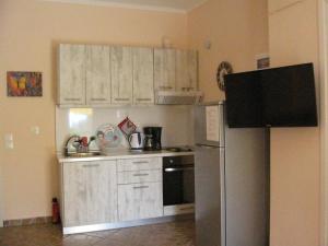 a kitchen with white cabinets and a refrigerator at Ground beach studio in Nea Potidaea