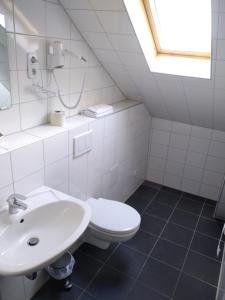 a white bathroom with a sink and a toilet at Hotel Zentrum in Grevenbroich