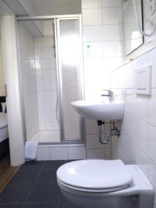 a bathroom with a toilet and a sink and a shower at Hotel Zentrum in Grevenbroich