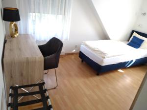 a small room with a bed and a desk and a chair at Hotel Zentrum in Grevenbroich