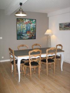 tavolo da pranzo con sedie e dipinto sul muro di Marioutat ad Arrens-Marsous