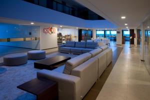 a lobby with couches and tables in a building at Ritz Suites Home Service in Maceió