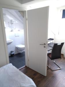 a bedroom with a bathroom with a toilet and a table at Hotel Zentrum in Grevenbroich