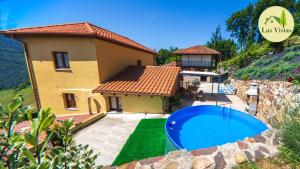a house with a swimming pool in front of it at Las vistas in Cornellana