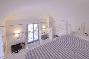 una scala vuota in una stanza bianca con materasso a righe di Blu mare a Finale Ligure