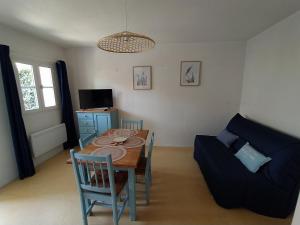 a living room with a table and a couch at Logement 106 2-4 Personnes 500 m plage classé 2 Etoiles in Dolus d'Oléron