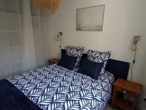 a bedroom with a blue and white bed with pillows at Logement 106 2-4 Personnes 500 m plage classé 2 Etoiles in Dolus d'Oléron
