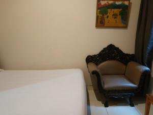 um quarto com uma cama, uma cadeira e uma fotografia em Pemda 22 Mansion Mitra RedDoorz em Bogor
