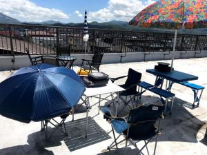 uma mesa e cadeiras com um guarda-sol num pátio em Big stone tsukuda / Vacation STAY 5916 em Aomori