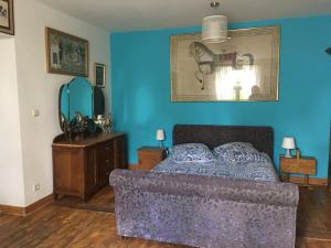 a bedroom with a bed and a blue wall at B&B Le Moulin de Fernelmont in Forville