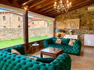 ein Wohnzimmer mit blauen Sofas und einer Steinmauer in der Unterkunft Akla Hotel Suites Valles Pasiegos in Saro