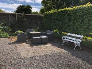 a bench and a table and chairs in a garden at Townley Hall Apartments in Slane