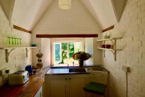 cocina con fregadero y ventana en Beautiful converted Stable in peaceful Somerset, close to the Jurassic Coast en Chard