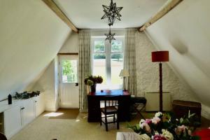 a living room with a table and a window at Beautiful converted Stable in peaceful Somerset, close to the Jurassic Coast in Chard