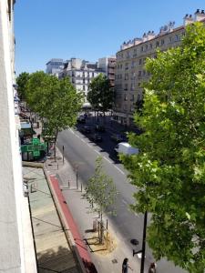 a view of a city street with trees and buildings at Hôtel Tingis in Paris