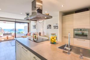 a kitchen with a sink and a counter with fruit on it at Lets Holidays garden house in front of the beach in Tossa de Mar