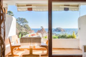 a dining room with a view of the ocean at Lets Holidays garden house in front of the beach in Tossa de Mar