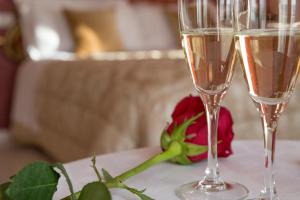 dos copas de champán en una mesa con una rosa en Home Grifondoro Affittacamere, en Génova