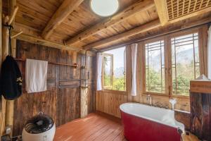 baño con bañera grande y ventana en Forest Glass inn, en Zhangjiajie