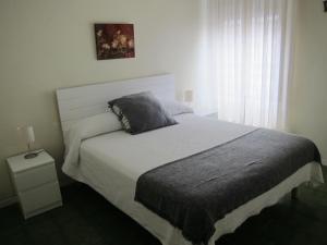 sypialnia z dużym łóżkiem i oknem w obiekcie BONITO APARTAMENTO TRIANA-LOS REMEDIOS w Sewilli