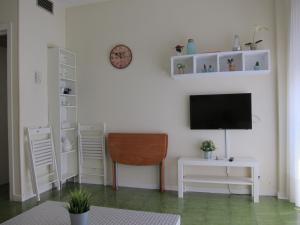 a living room with a tv and a desk and a chair at BONITO APARTAMENTO TRIANA-LOS REMEDIOS in Seville