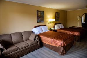 a hotel room with two beds and a couch at Kings Inn Hot Springs in Hot Springs