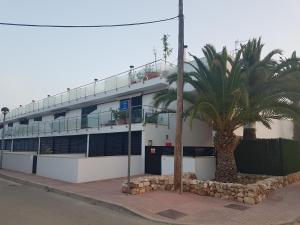 a building with palm trees in front of it at Apartamento Sa Perdiu 16 in Son Carrio