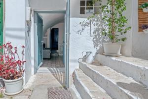 un callejón con macetas en las escaleras en Le Piccole Case Bianche, en Ostuni