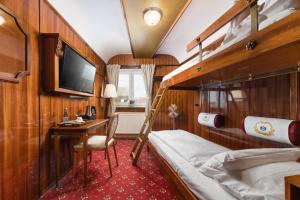 une chambre de train avec des lits superposés et un bureau dans l'établissement Hôtel du Train, à Munich