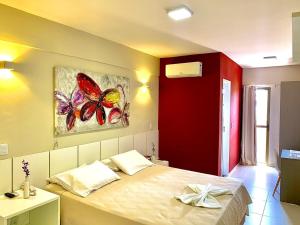 een slaapkamer met een bed met een schilderij aan de muur bij Murano Center Hotel in Limoeiro do Norte